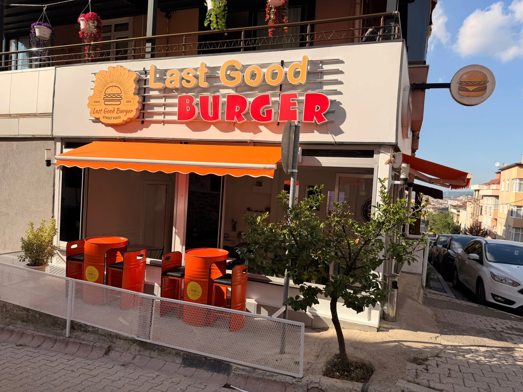 Last Good Burger dış cephesi, turuncu tente ve oturma alanı